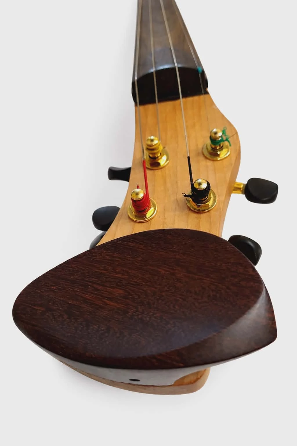 Detail view of the lower part of the Koton violin with gold pegs and chinrest